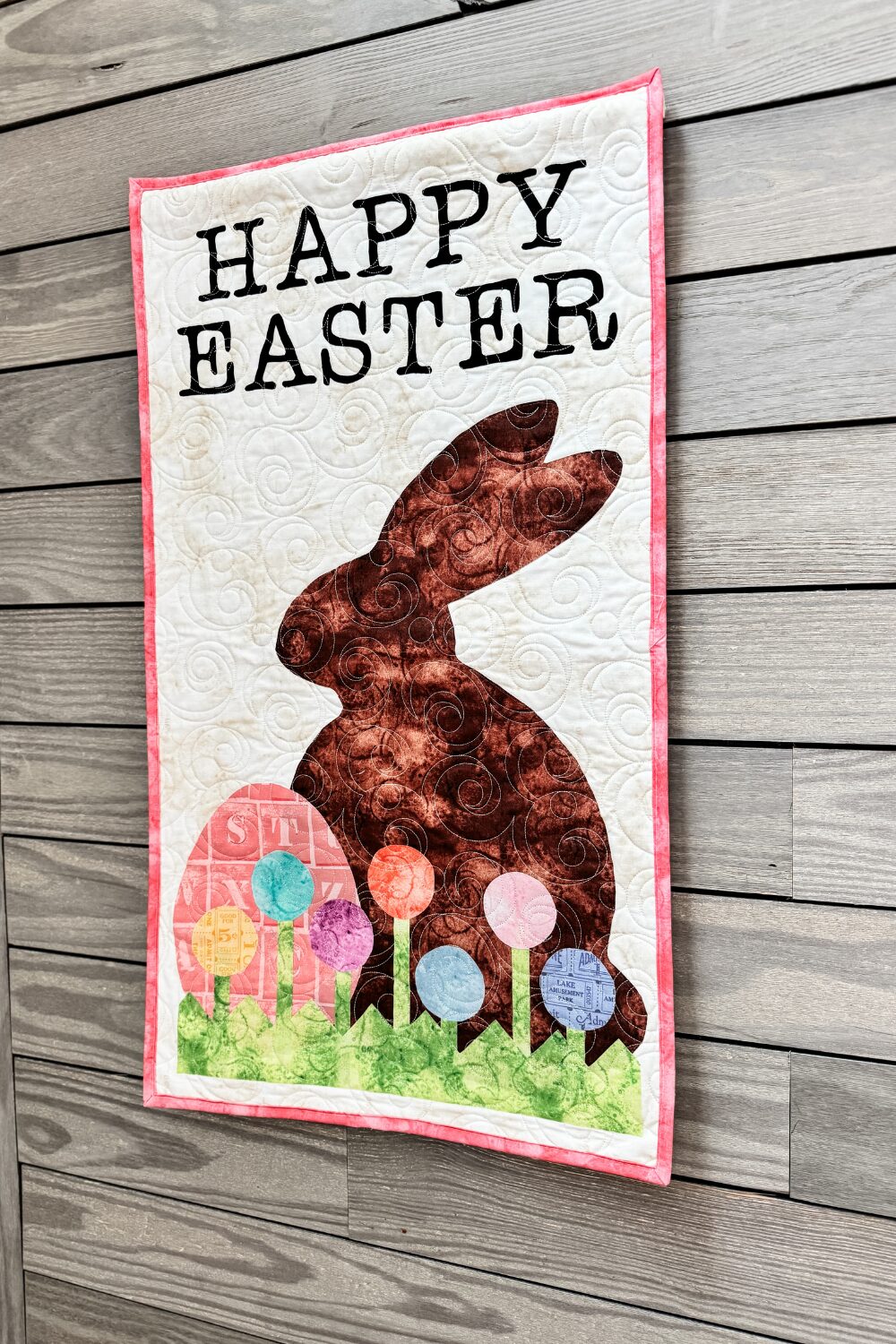Quilted Happy Easter door banner in pastel colors hanging on a wall for seasonal decor.