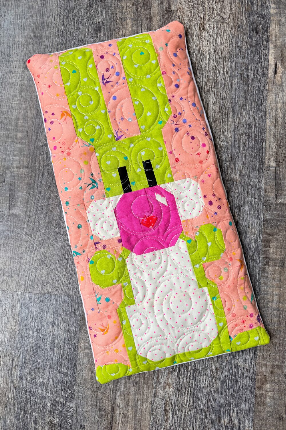 Spring-themed quilted bench pillow with a bunny design made from leftover fabric scraps.