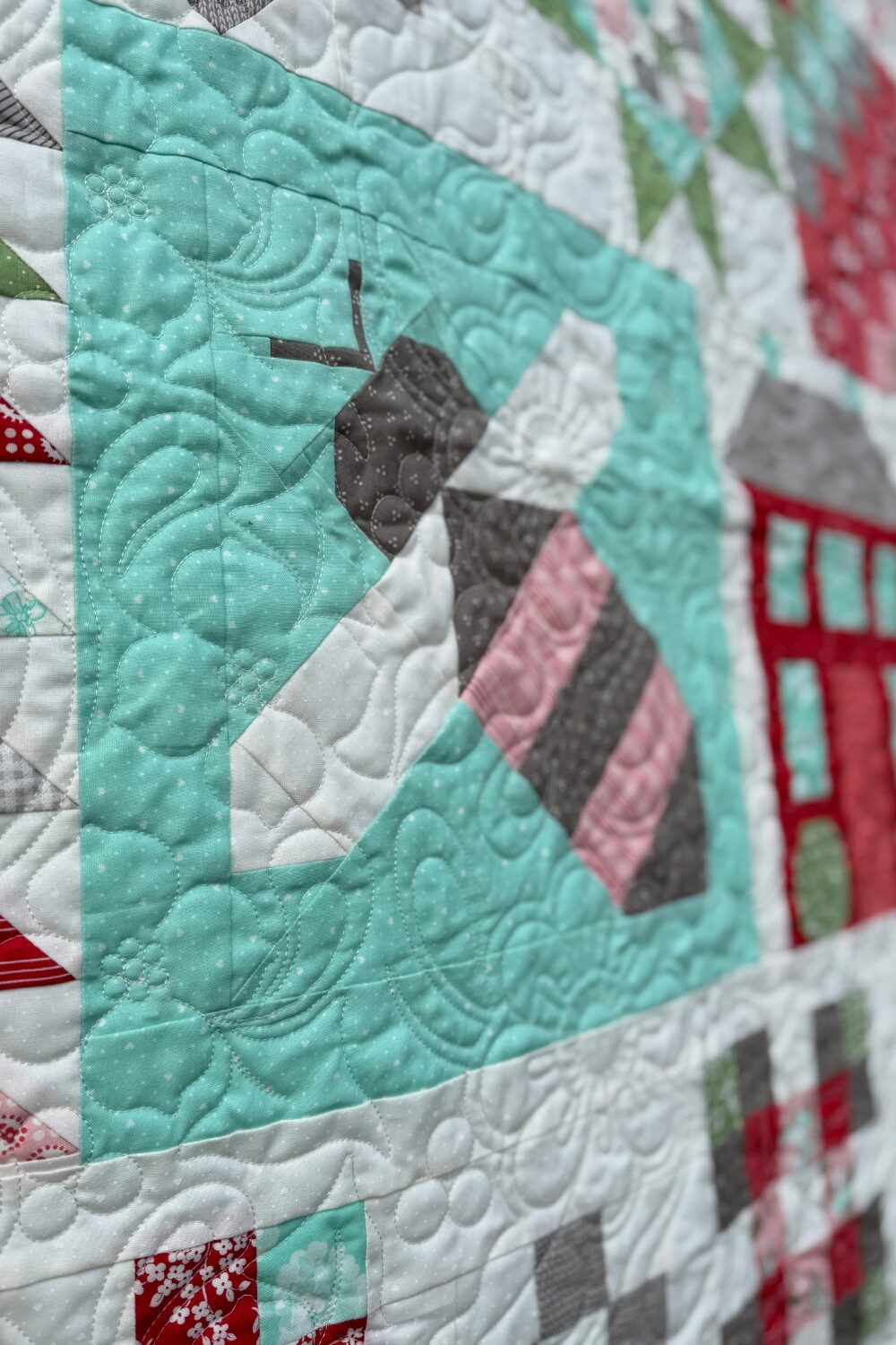 Bee block close-up from second Shine Bright quilt quilted with Dogwood Bouquet pantograph.