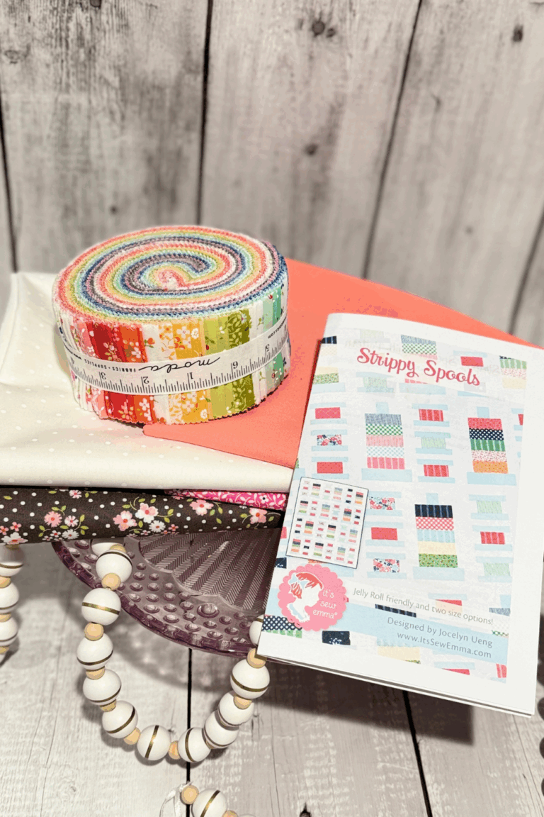 Strippy Spools quilt pattern with Cali & Co jelly roll, Carnation Bella Solid, and Magic Dot background fabric.