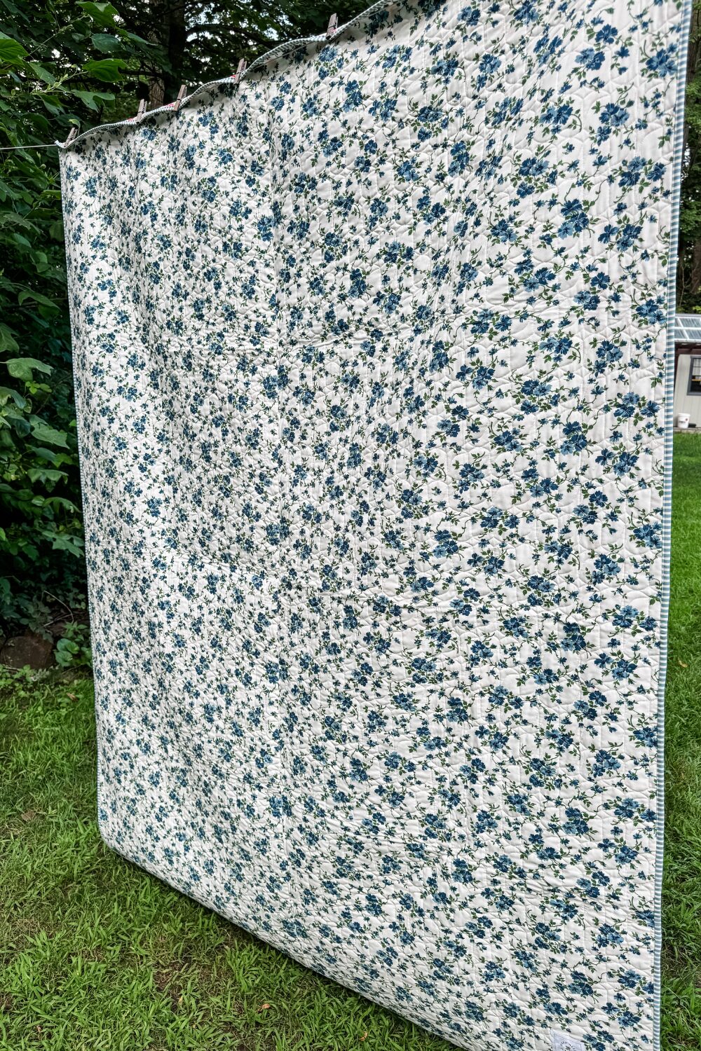 Backing fabric of the Piece and Quilt Sampler quilt featuring a blue and green floral print from the Shoreline collection.