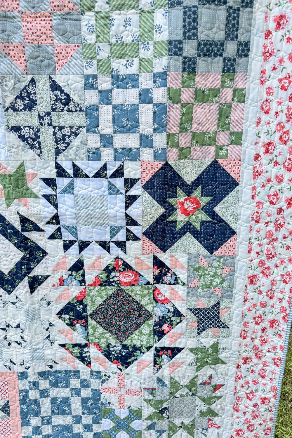 Side view of quilt showing sampler blocks, inner white border, and pink floral outer border.