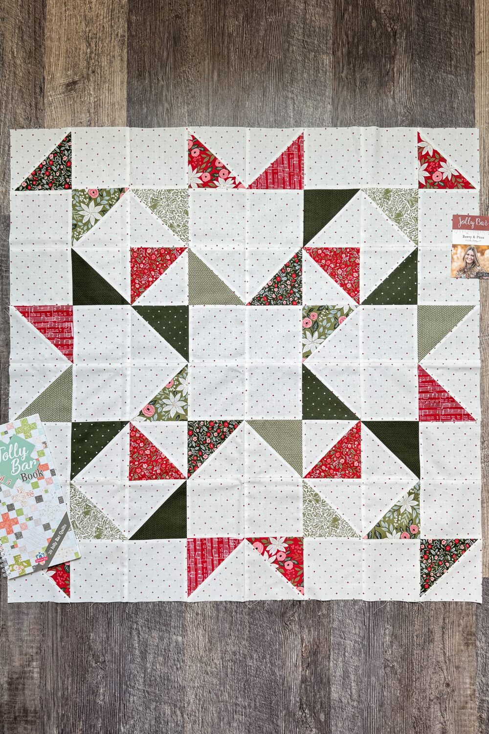Finished Scattered Stars quilt block from the Jolly Bar 5 Quilt Along using Berry & Pine fabrics. Shown with the Jolly Bar 5 quilt book