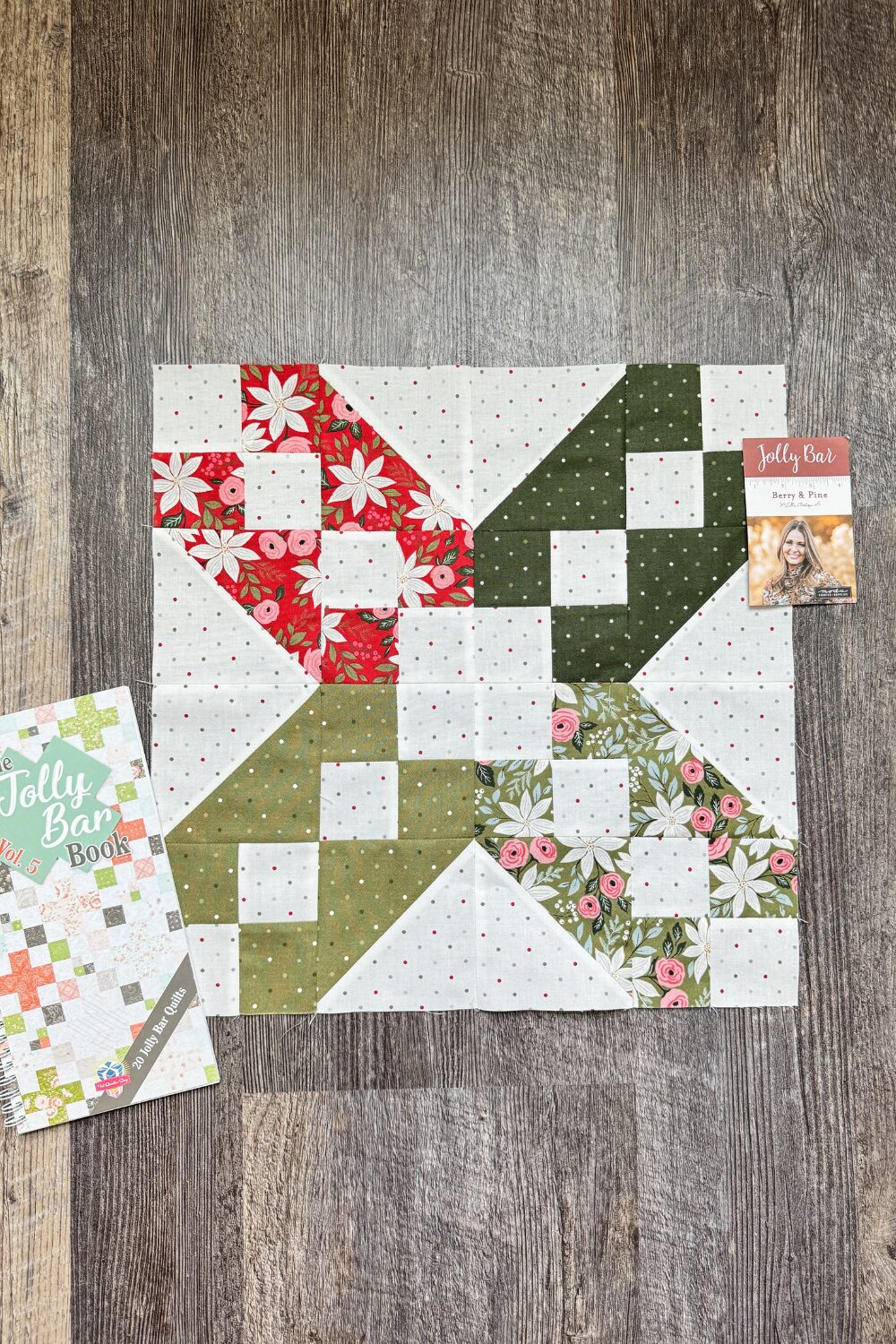 Styled photo of the completed 16.5-inch XOXO quilt block for the Jolly Bar 5 Quilt Along.