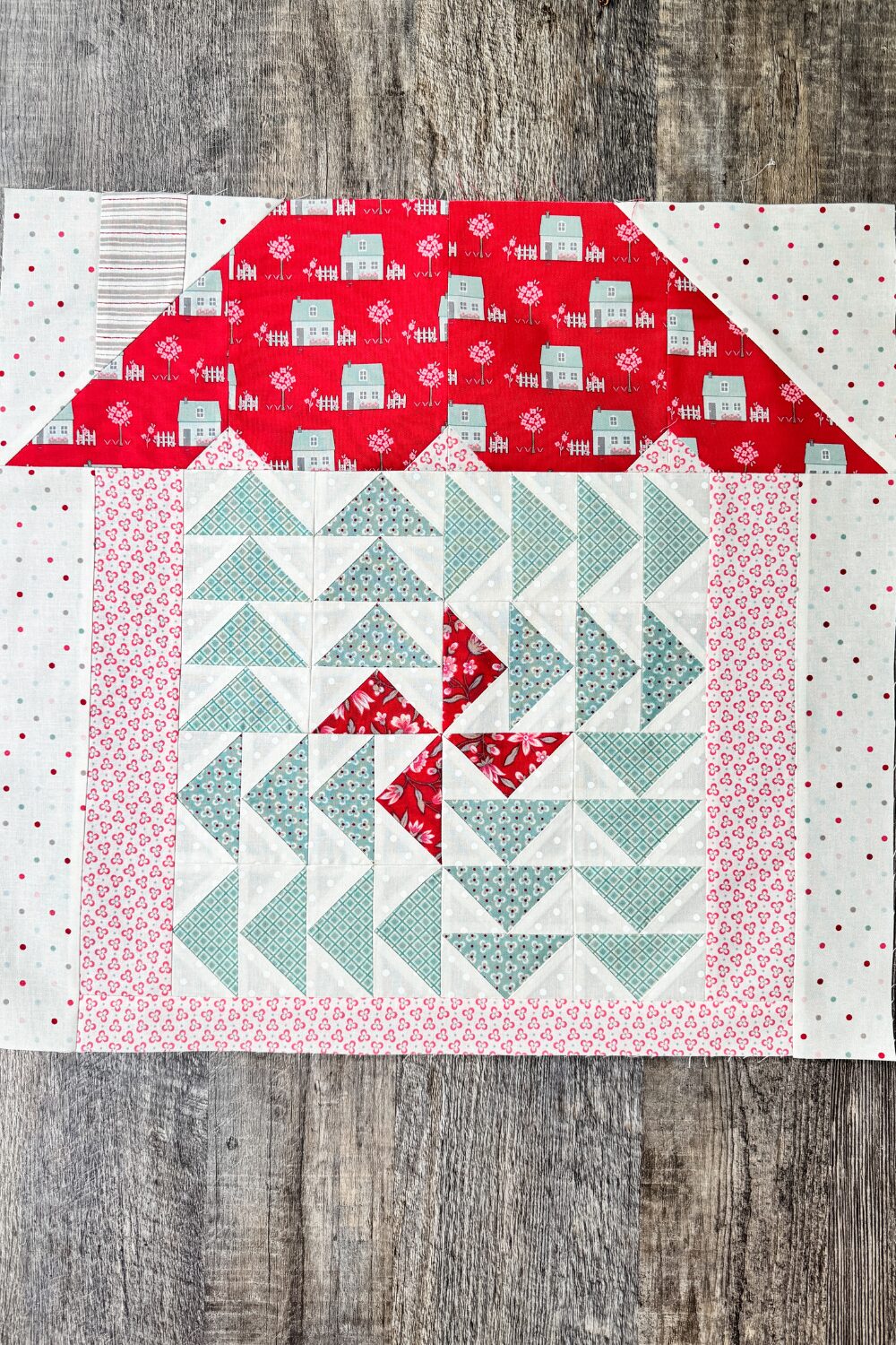 Finished 12" Family Time quilt block with red and blue flying geese forming a pinwheel.