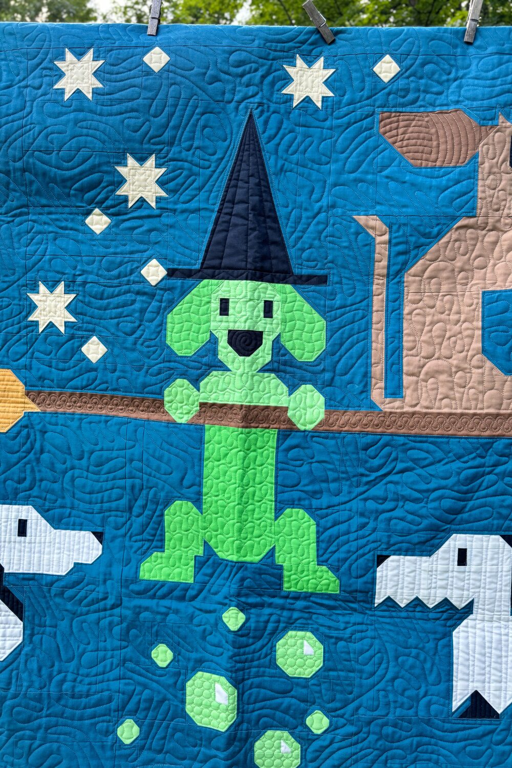 Witch weiner dog from the Halloweenies Quilt flying on a broom with a hat.