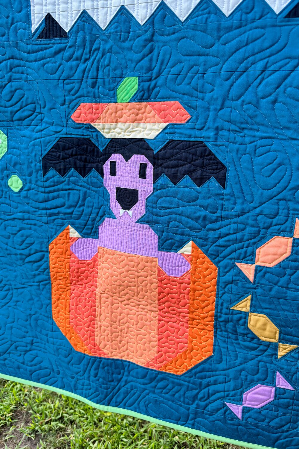 Vampire weiner dog from the Halloweenies Quilt with bat wings and fangs peeking out of a pumpkin.