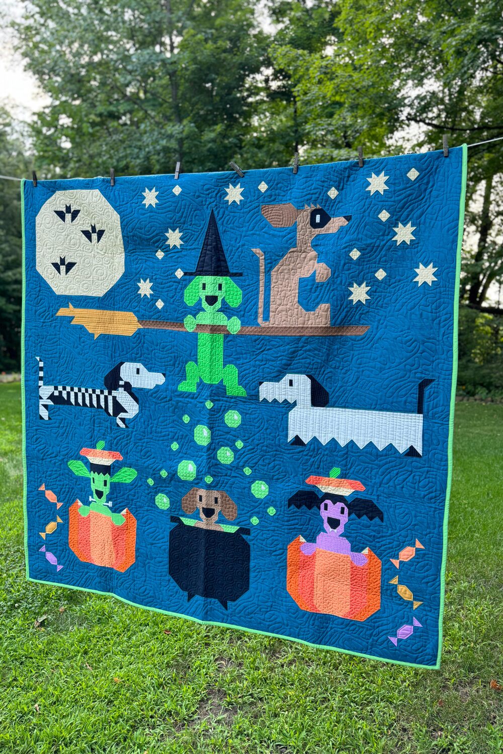 Halloweenies Quilt displayed showing detailed custom quilting and bright solid fabrics.