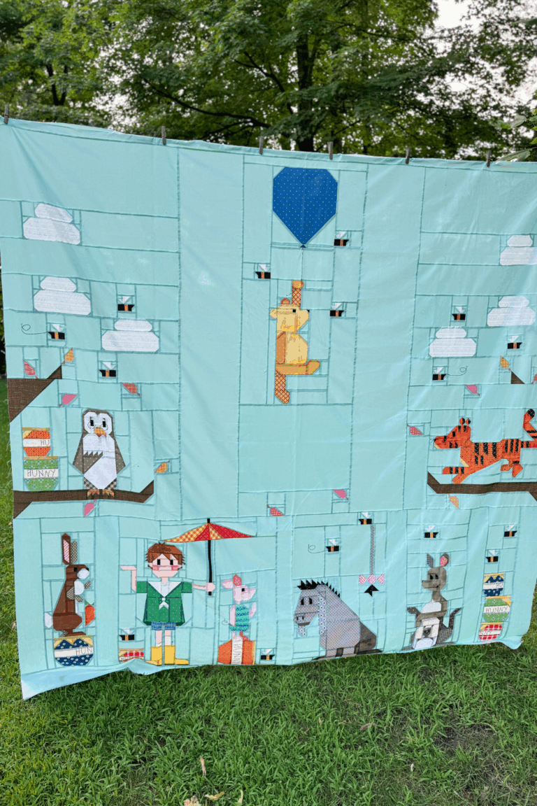 Full 100 Acre Wood quilt top on light blue background in larger 90x90 layout showing complete design and filler blocks.