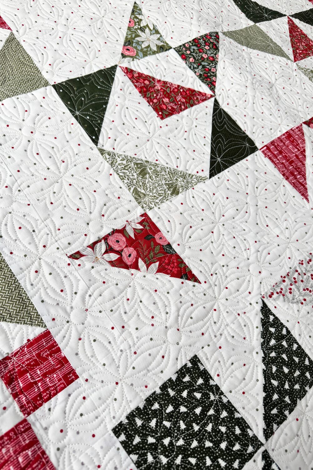 Close-up of quilting stitches on the finished Jolly Bar 5 sampler quilt.