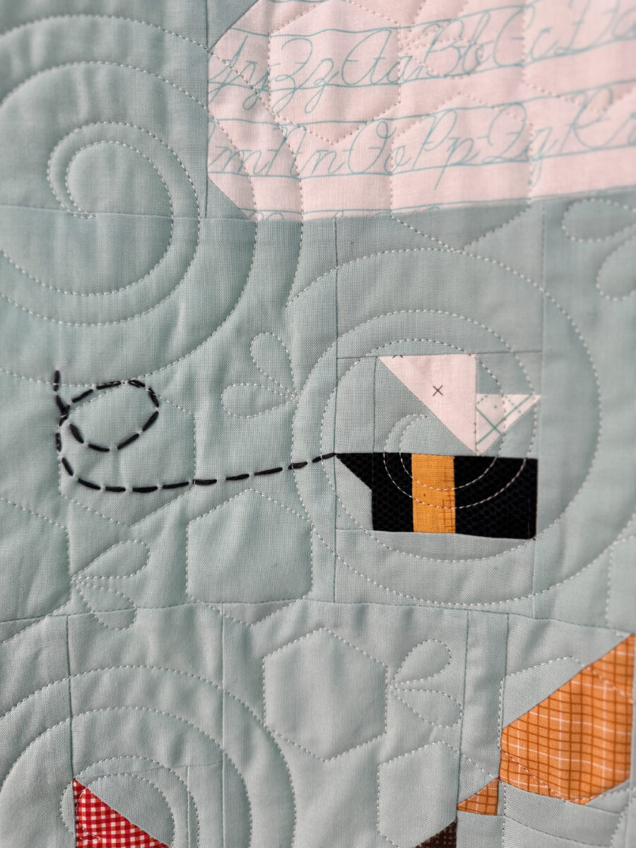 Close-up of embroidered bee trail on the Winnie the Pooh quilt.