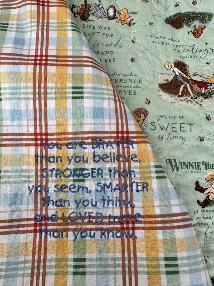 Close up of embroidered quote inside quilt coat reading You're stronger than you think.