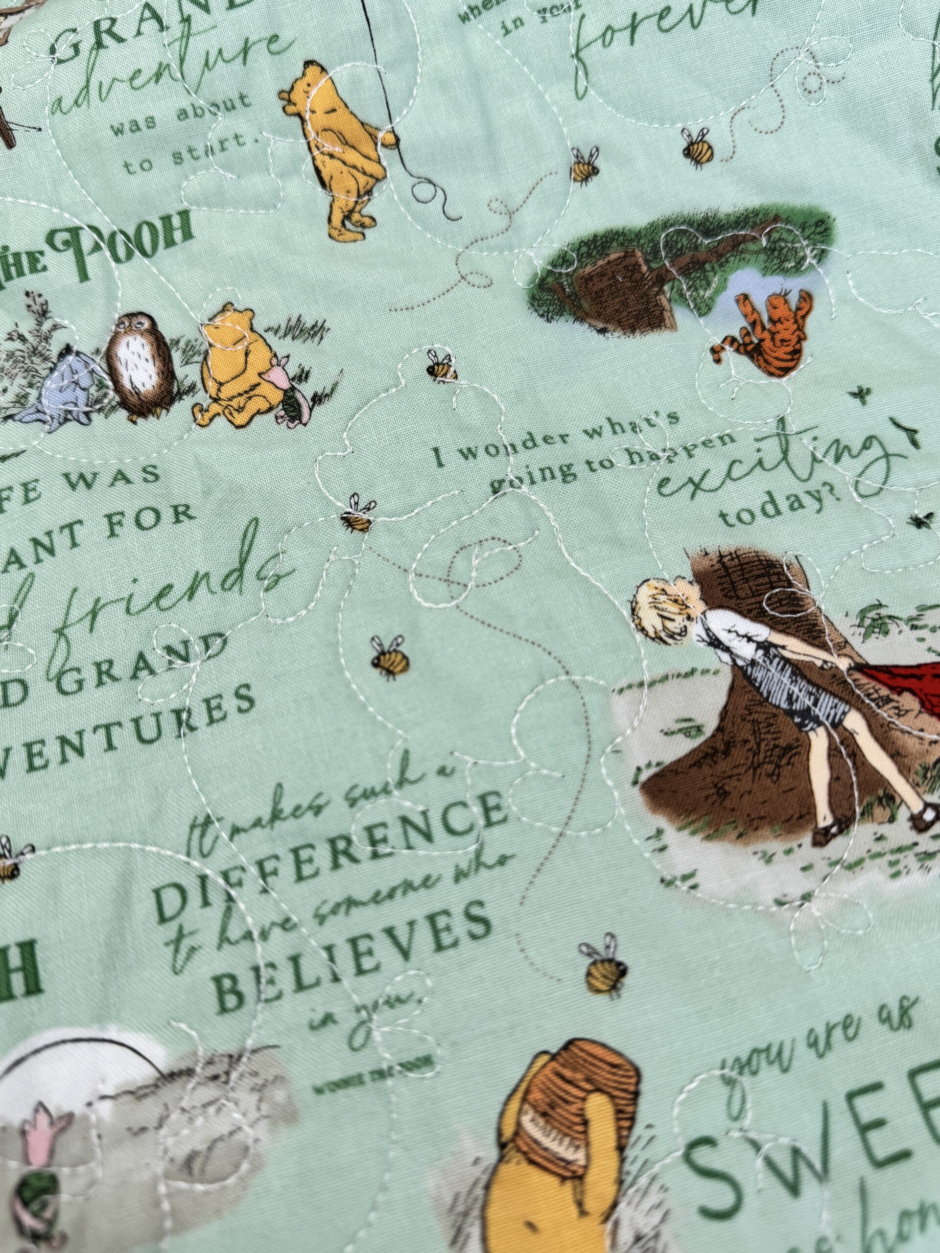 Close up of Winnie the Pooh pantograph quilting on front of quilt coat.