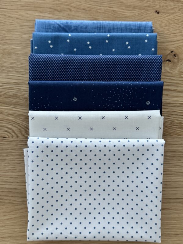 Flurry Seasonal Basics Petite fat quarter bundle laid in one row with light blue and white Riley Blake Basics