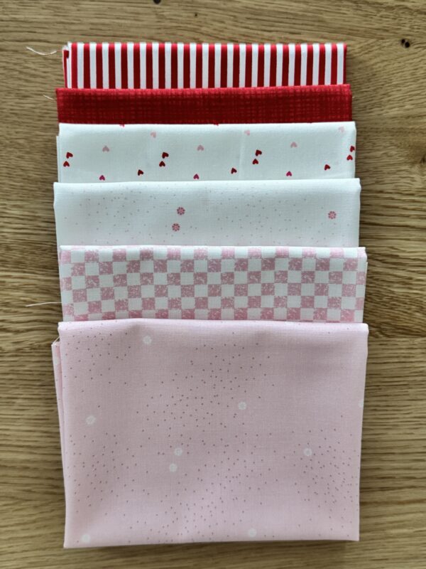 Hearts Seasonal Basics Petite fat quarter bundle laid in one row with pink and white Riley Blake Basics