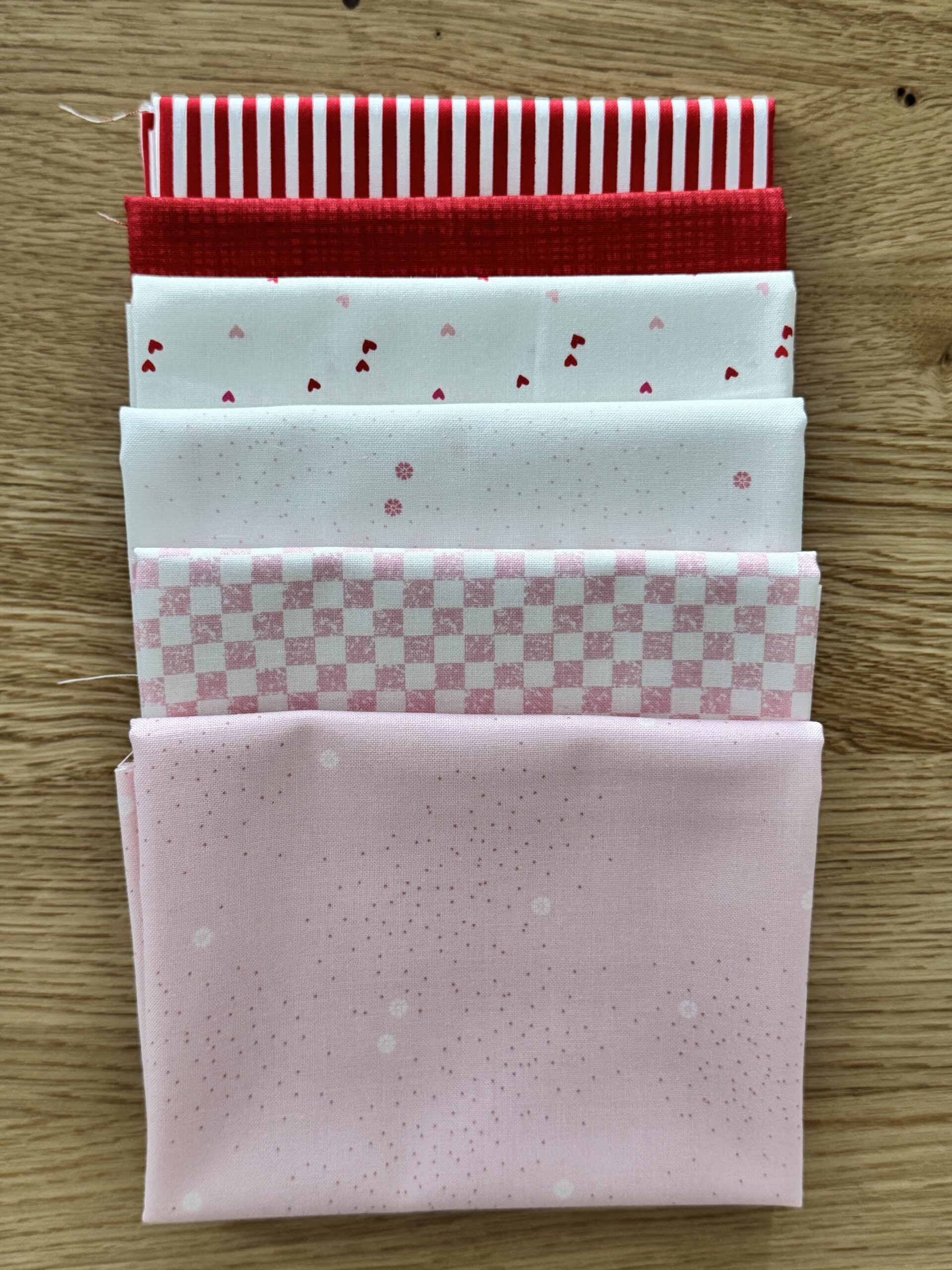 Hearts Seasonal Basics Petite fat quarter bundle laid in one row with pink and white Riley Blake Basics