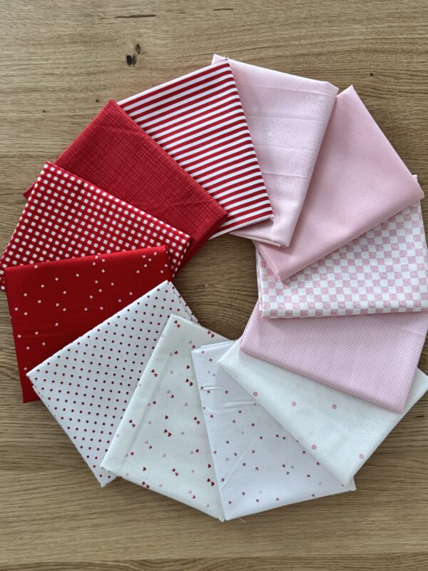 Sweetheart Seasonal Basics 12 piece fat quarter bundle fanned in a circle with pink, red, and white Riley Blake Basics