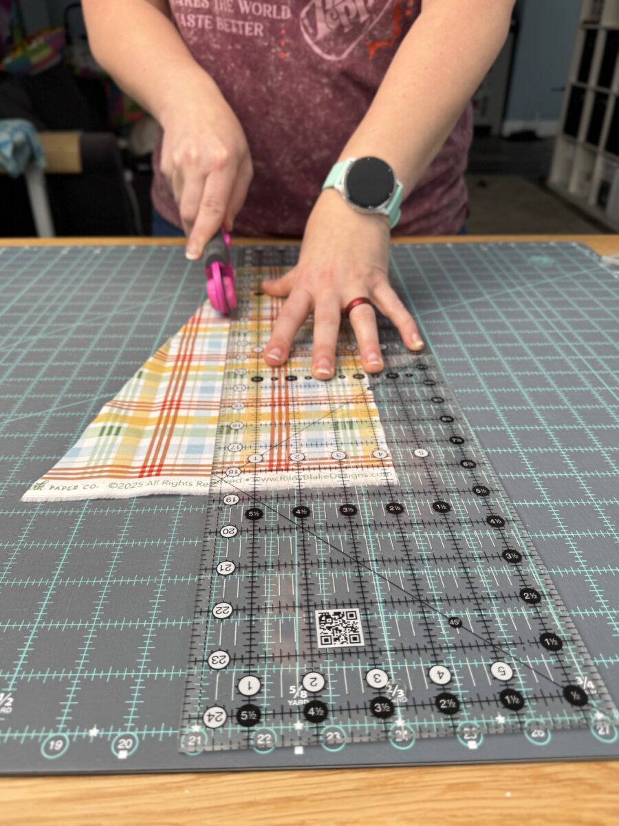 Standing square while cutting fabric with a rotary cutter and ruler.