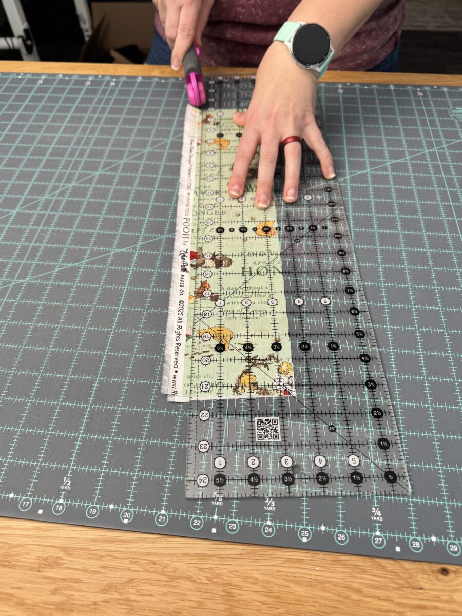 Cutting a long strip of fabric while keeping the stable and even with the rotary hand.