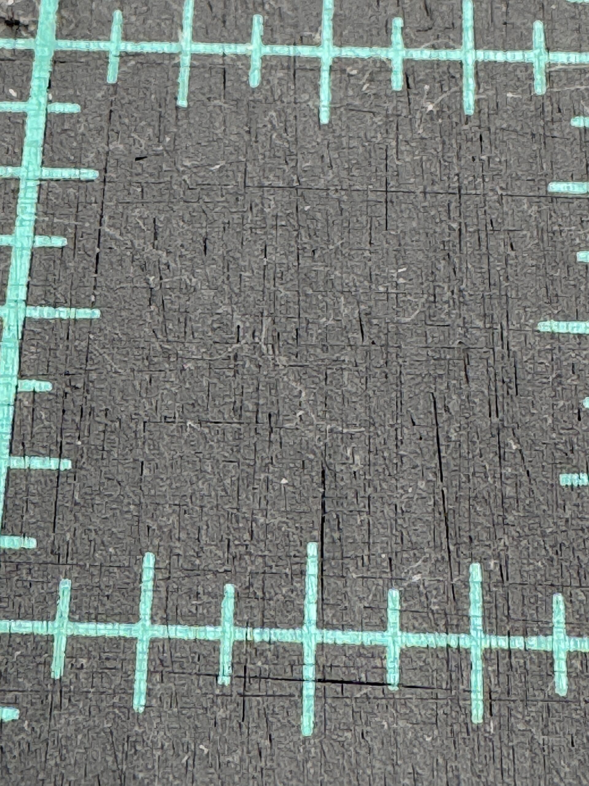 A close up view of tiny cuts in a self healing cutting mat. This is showing that the mat is nearing the end of its useful life. This affects accurate cutting for quilting.
