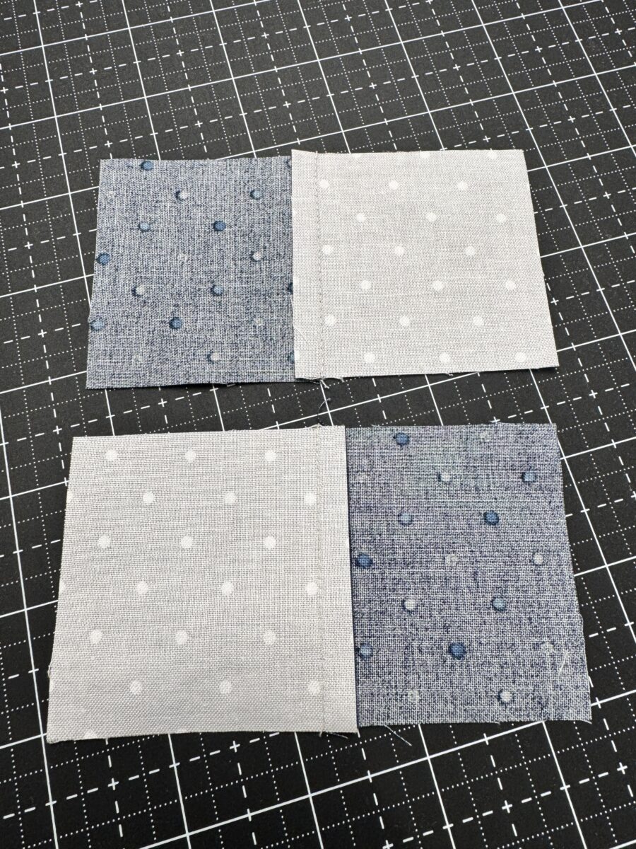 Backside of two sewn fabric pairs with seams pressed toward the blue fabric for nesting