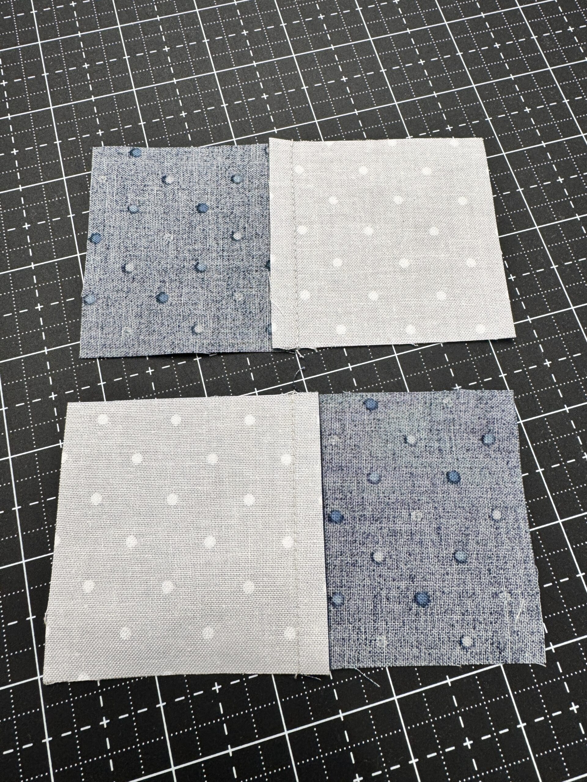 Backside of two sewn fabric pairs with seams pressed toward the blue fabric for nesting