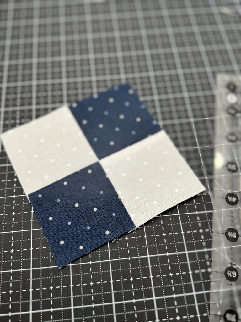 Completed four patch unit using nested seams pressed open with a sharp, perfectly aligned center intersection