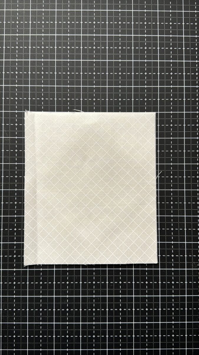 Wrong side of fabric glued to wrong side of foundation paper for flying geese foundation paper piecing