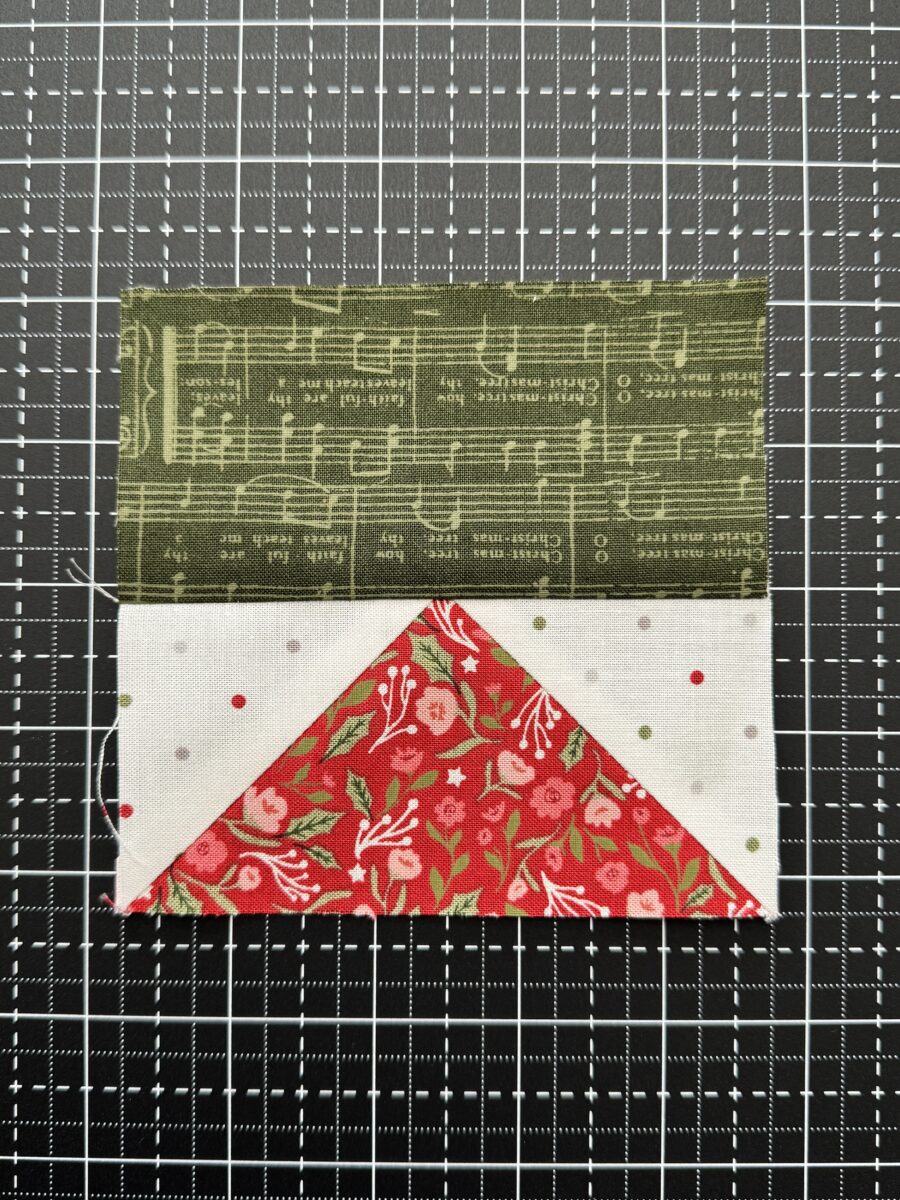 Flying geese unit sewn to a rectangle with the top point cut off due to inaccurate seam allowance