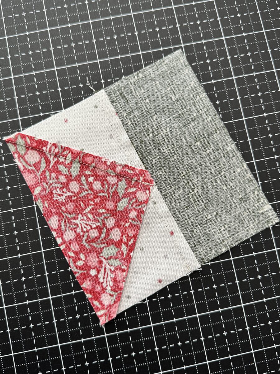Backside of flying geese and rectangle unit showing seam allowances pressed to one side
