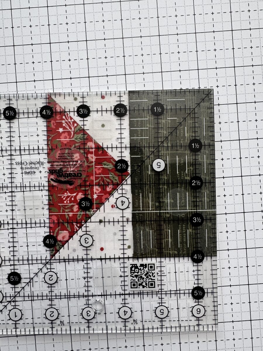 Quilting ruler placed over a correctly sewn flying geese unit to check size and point placement