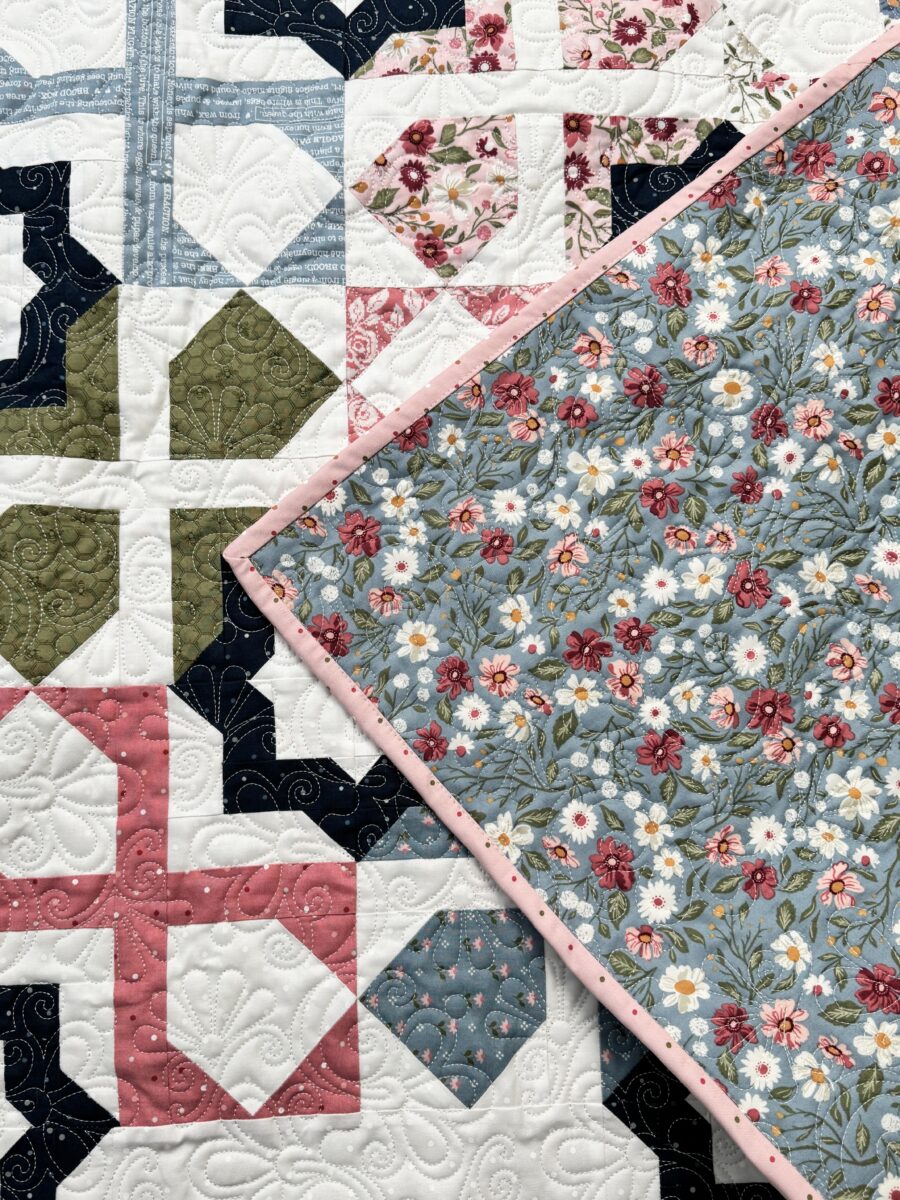 Corner of Dreamer quilt flipped forward to show backing fabric and coordinating binding.