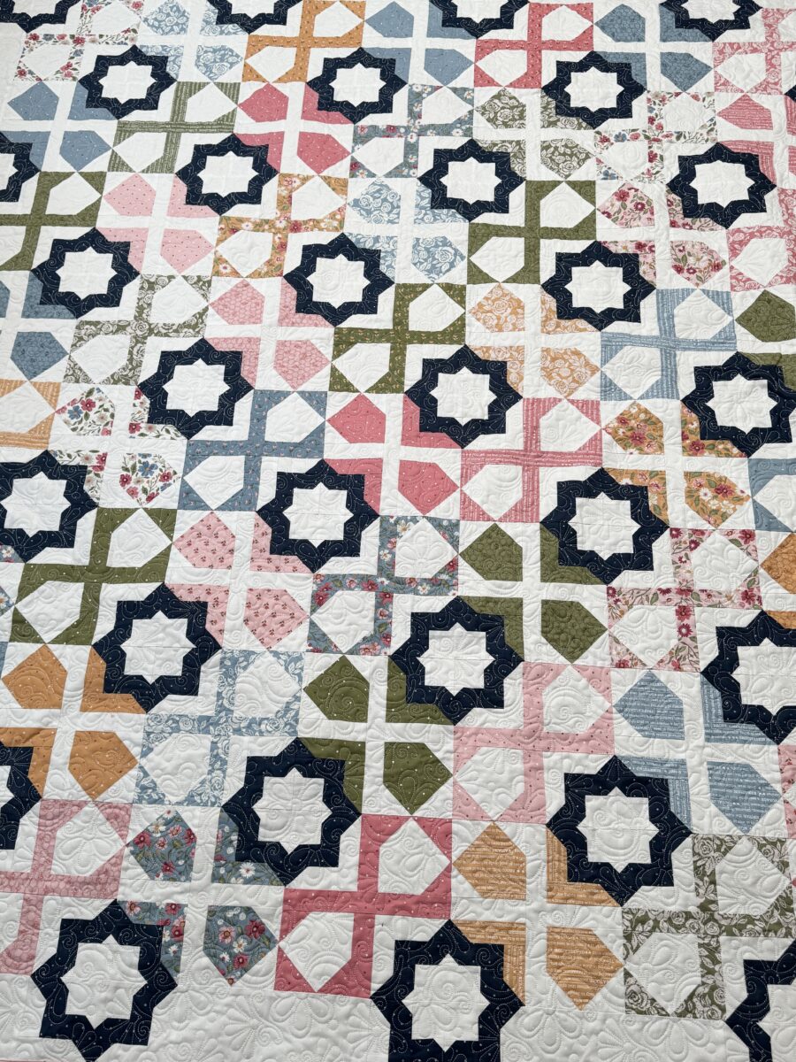 Overhead view of Dreamer quilt showing geometric layout and navy accent stars.