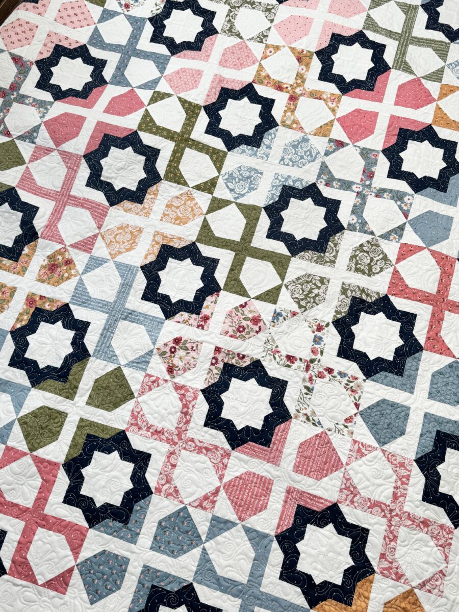 Angled overhead photo of Dreamer quilt highlighting detailed patchwork and color placement.