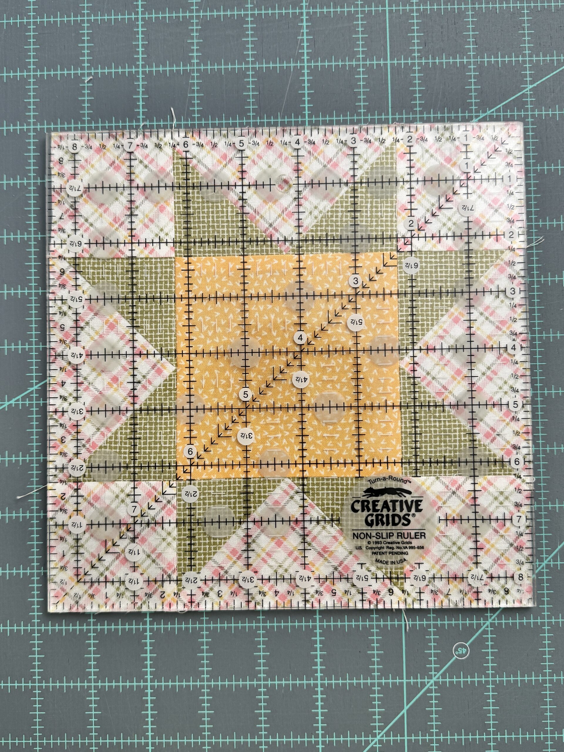 Aligning a square ruler on top of a quilt block that is the same size