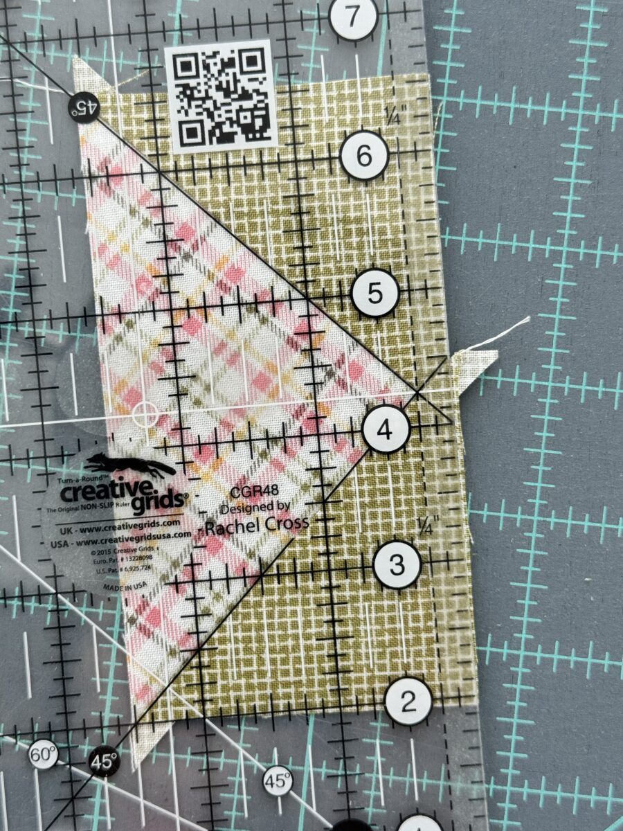 Close up of ruler laid on Flying Geese unit ready to trim