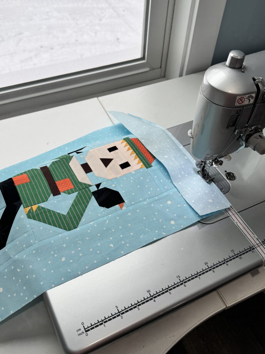 Large quilt block being sewn with an extension table supporting the fabric