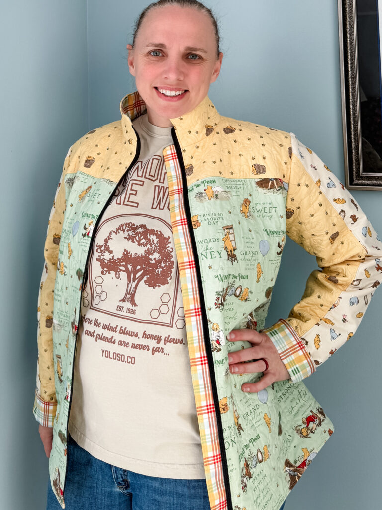 Quilter posing in Winnie the Pooh Bella Quilt coat with zipper open, showing zipper guard details