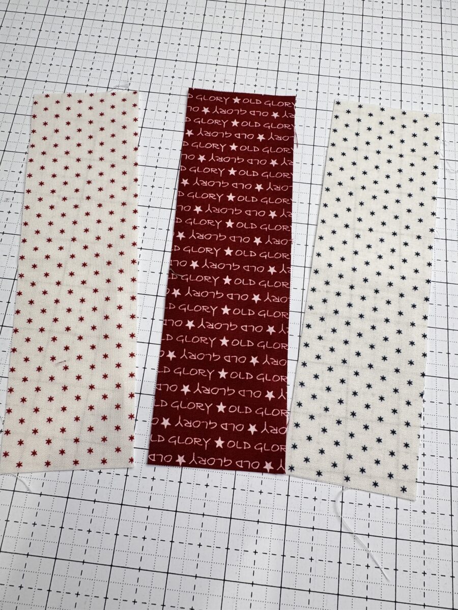 three 2.5 inch fabric strips prepared for strip piecing a rail fence quilt block