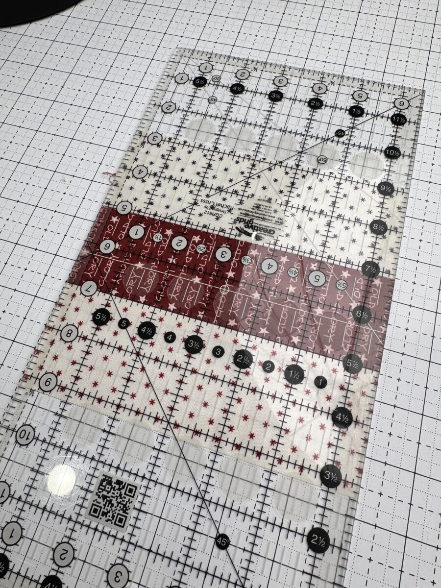 rail fence quilt block being squared up under a ruler to 6.5 inch unfinished size