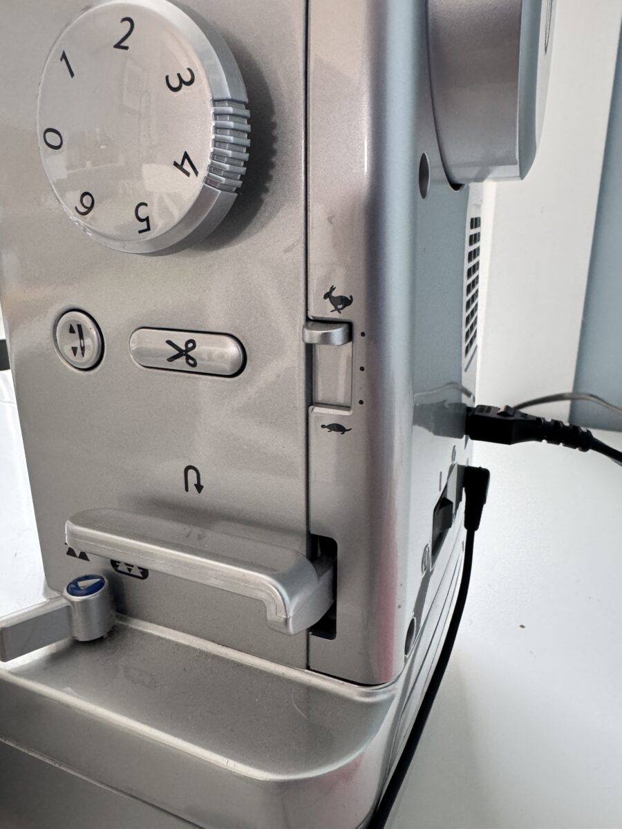 Close-up of sewing machine speed control setting used to maintain steady stitching for straight seams