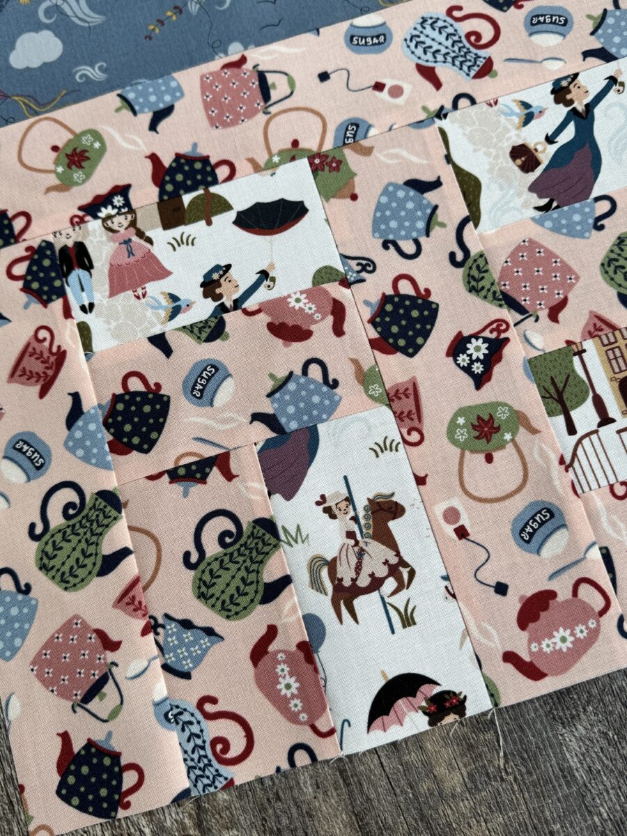 Close up of house quilt block showing fussy cut carousel horse in doorway and window details