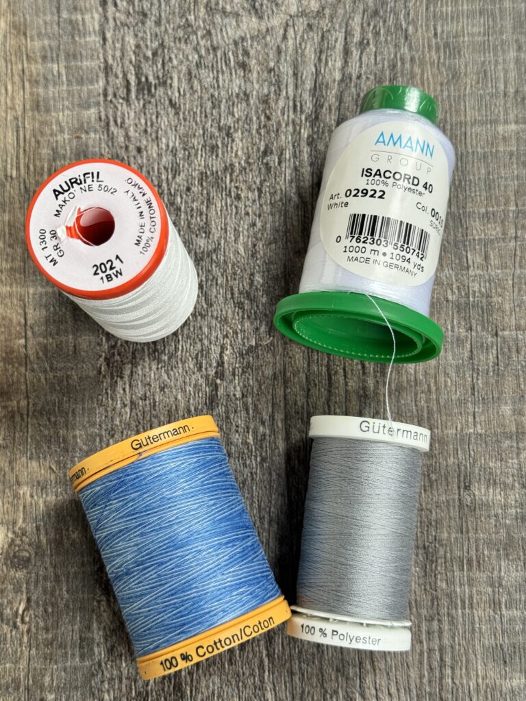 A variety of thread spools with different colors, weights, and materials