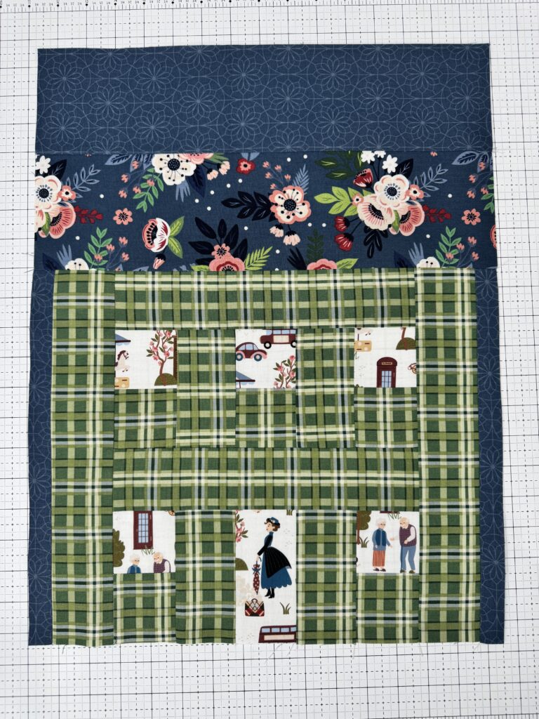 Green plaid house quilt block with blue floral roof and Mary Poppins fabric windows and door