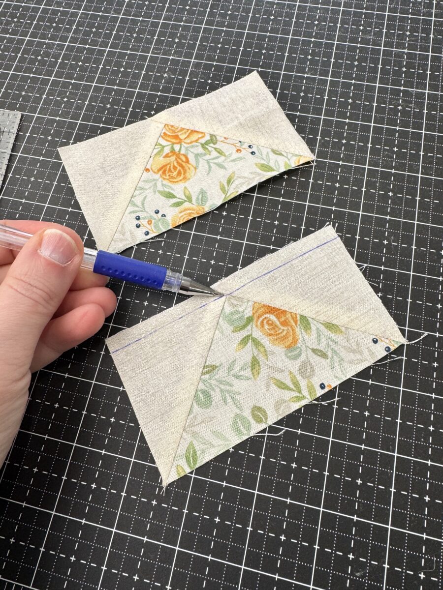 Pen pointing at the tip of a flying geese unit highlighting the critical intersection point to sew through