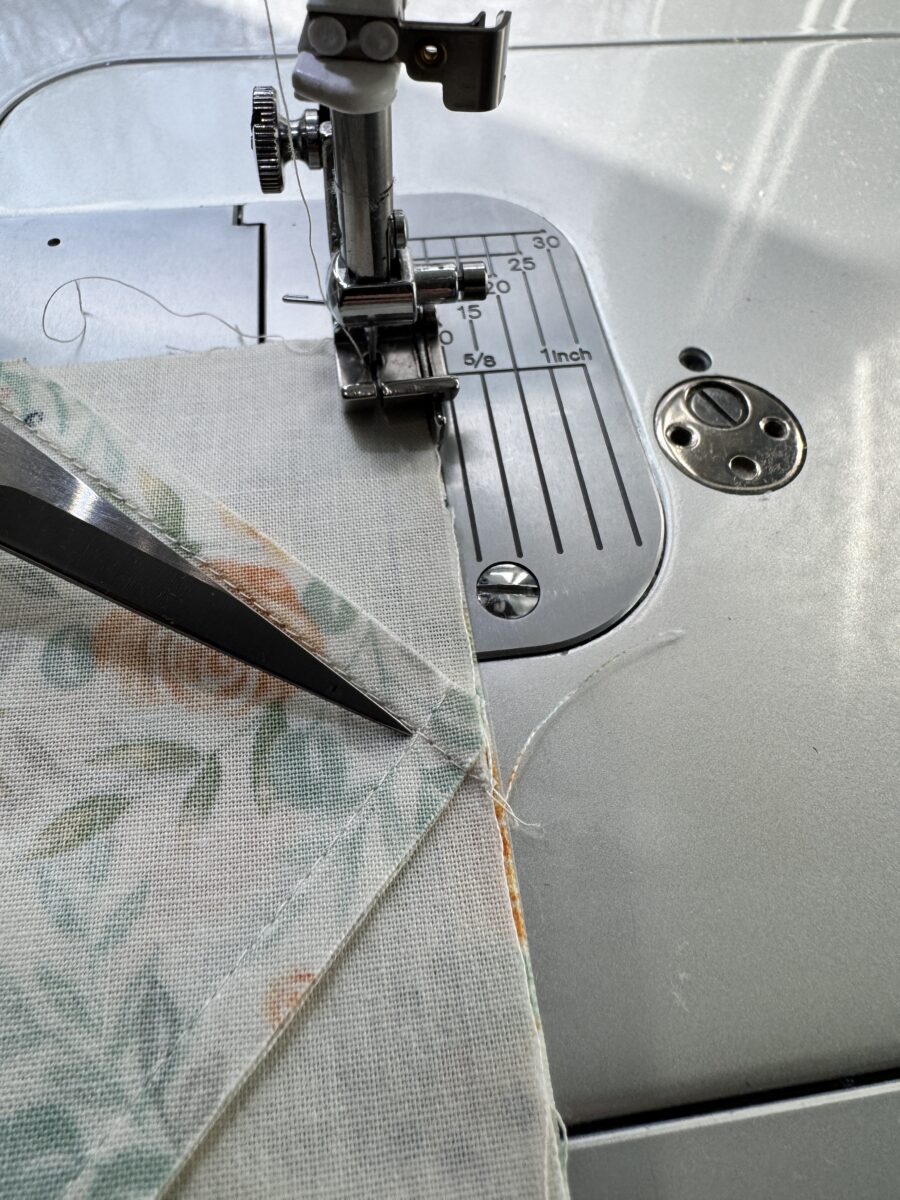 Close up of quilt stitching on the back showing a scant quarter inch seam that preserves the flying geese point
