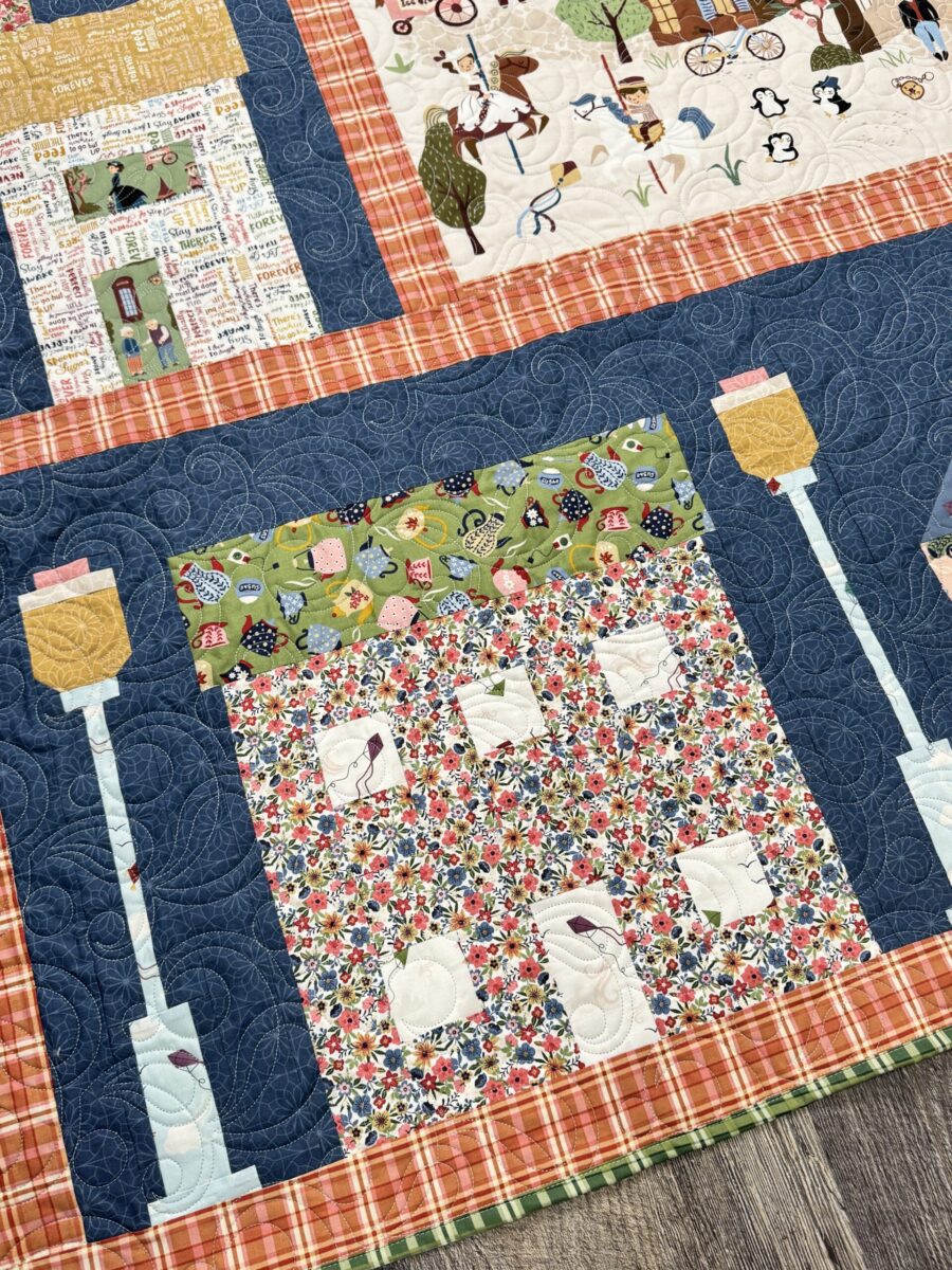 Close angled view of house blocks in Mary Poppins quilt showing fabric details and layout