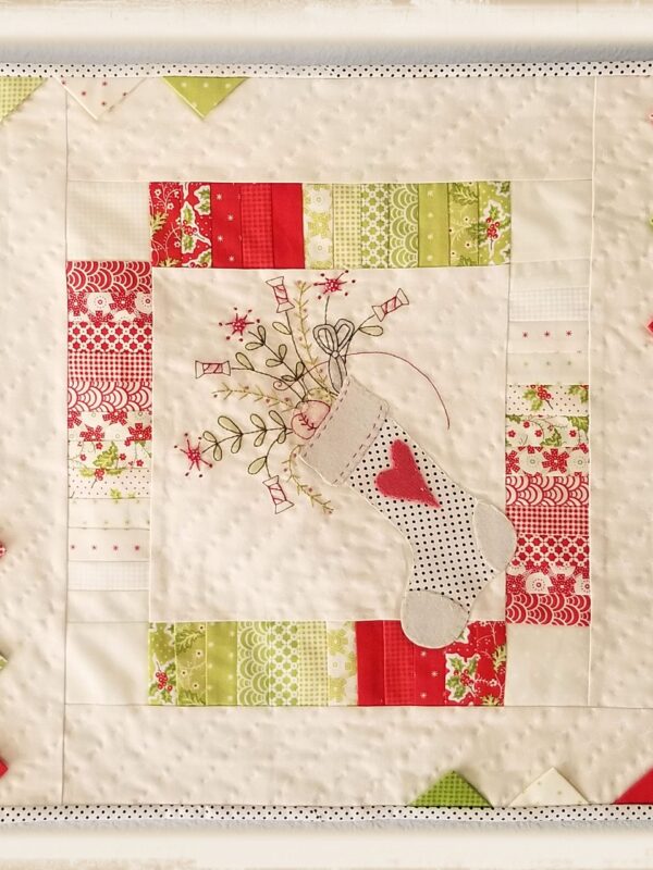A Stitcher’s Stocking mini quilt pattern by Plumcute featuring patchwork, appliqué, and embroidery design