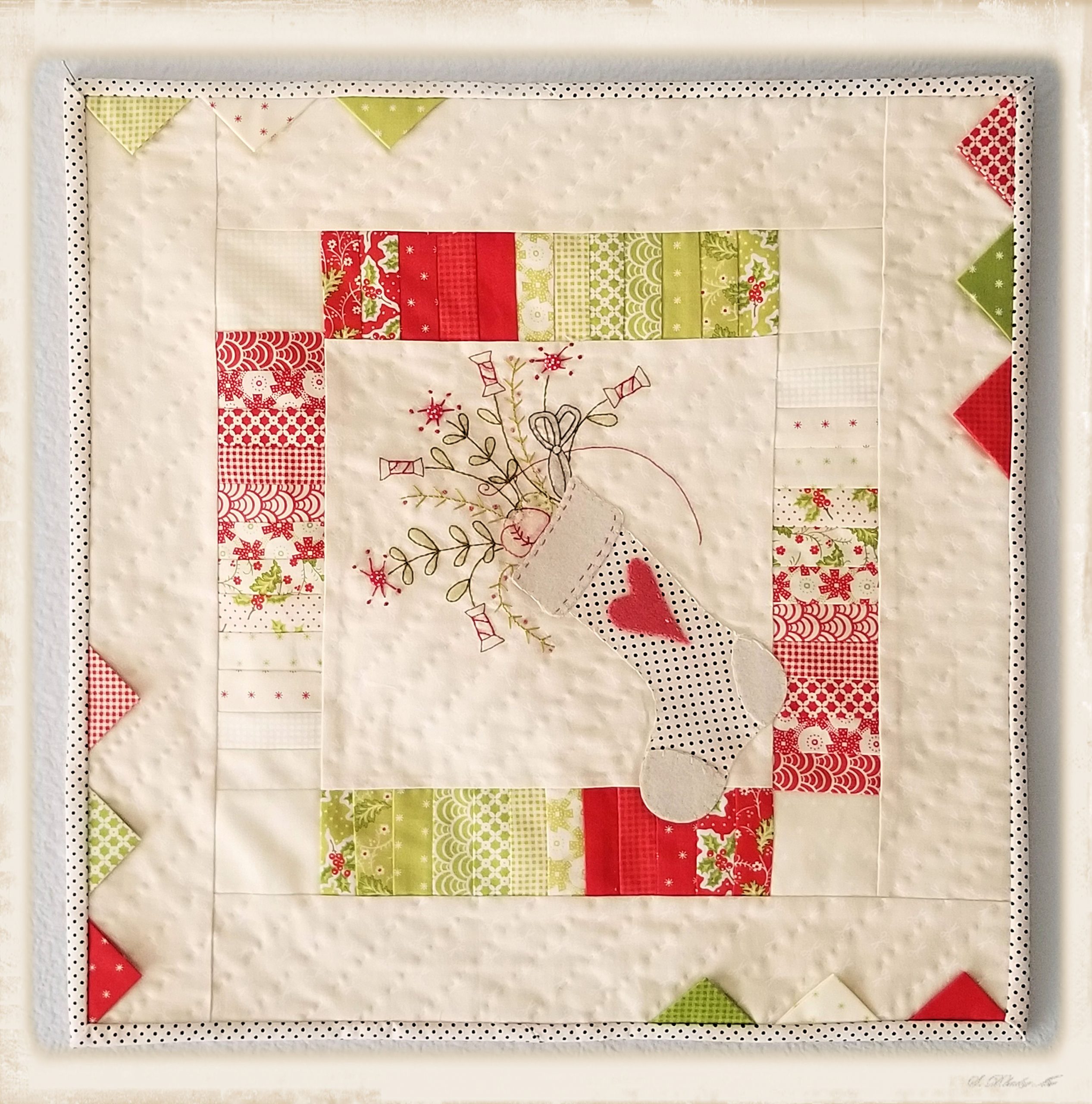 A Stitcher’s Stocking mini quilt pattern by Plumcute featuring patchwork, appliqué, and embroidery design