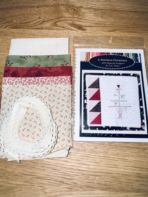 A Stitcher’s Christmas embroidery kit by Plumcute Designs including fabric, trim, and heart button for spool tree design